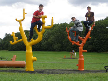 Image of tree scultures with youths climbing/sitting on them